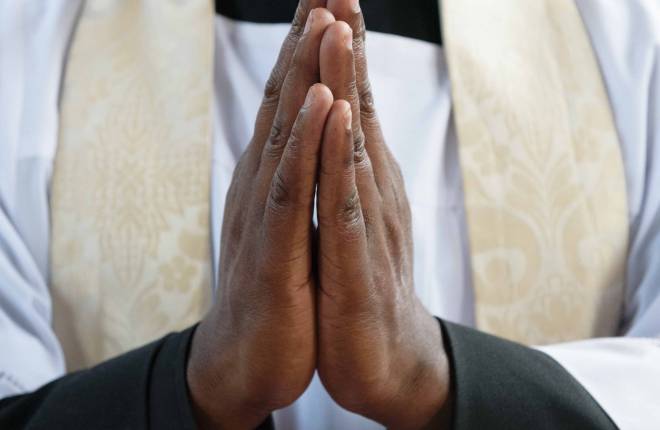 Clergy with hands together in prayer